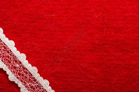 红纺织品背景上的白色旧带子图片