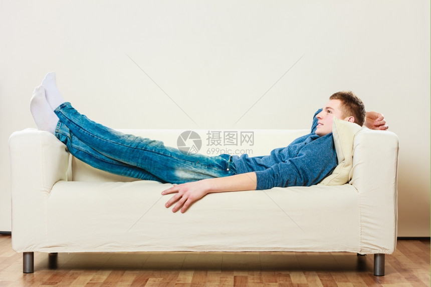 在家休闲概念英俊的年轻人在沙发上休息躺在床做梦图片