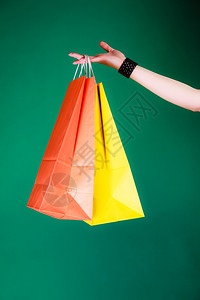 售货时间工作室的绿色背景女人手拿着购物袋图片