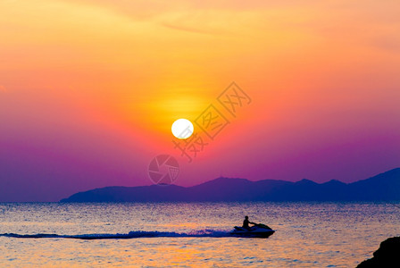 在日落时海面上有行驶的摩托艇图片