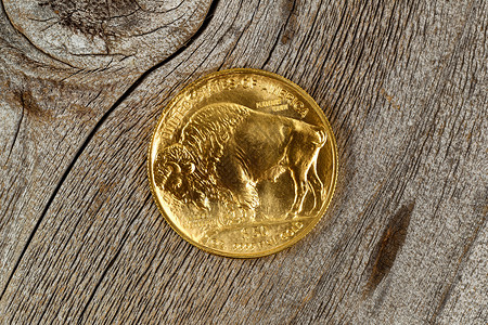 美国金牛城硬币的反面精美金子在生锈木头上背景图片