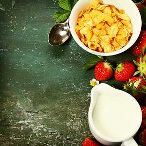 健康早餐玉米片牛奶和草莓以旧木制背景图片