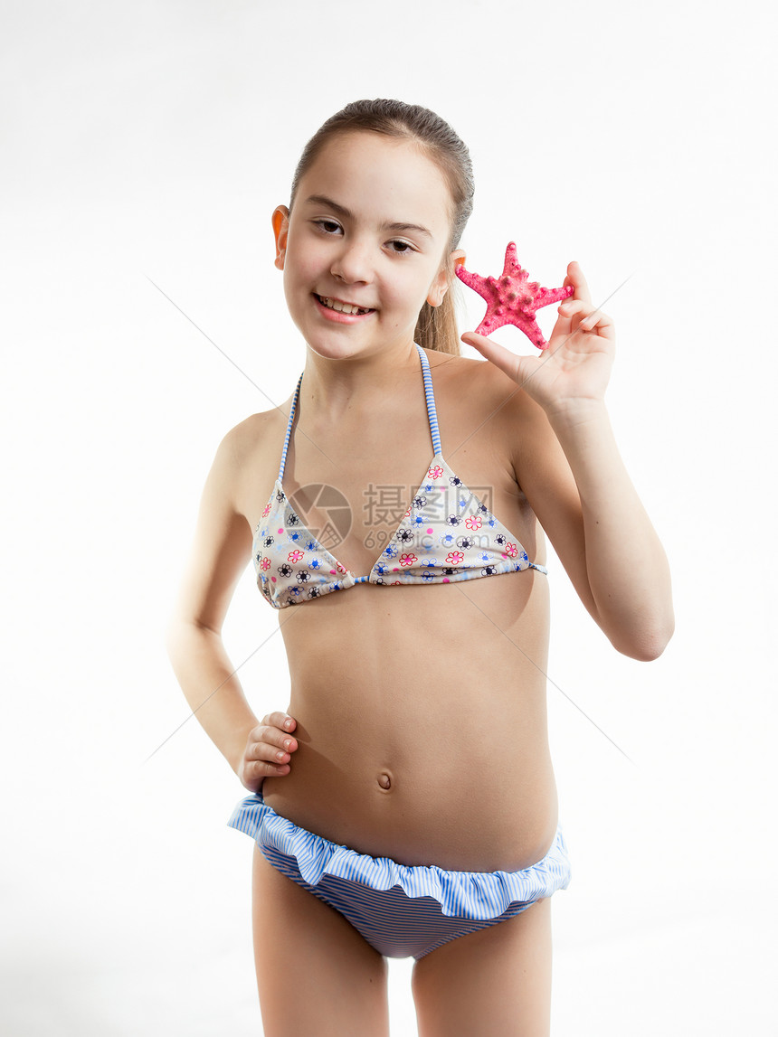 穿泳衣的快乐女孩肖像显示红海星的图片