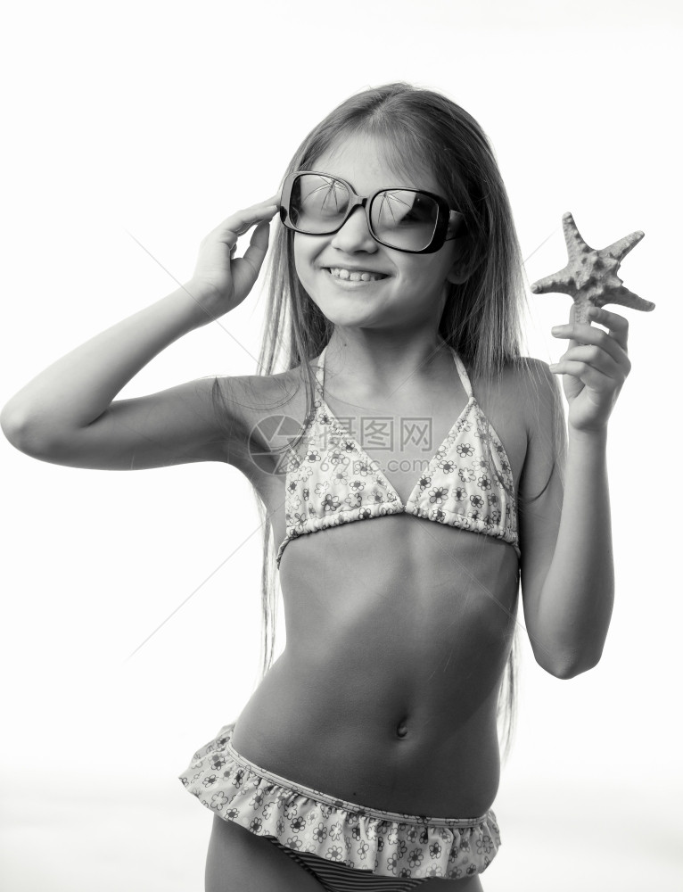 黑白孤立的快乐女孩画像穿着泳装抓海星的服图片