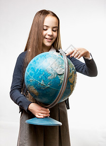 穿着校服的可爱笑女孩指着地球图片