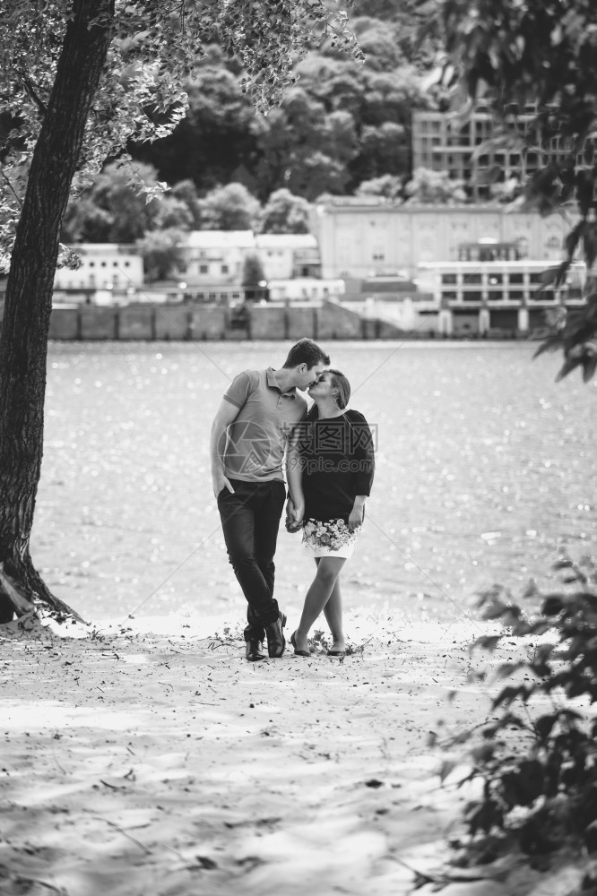 黑白照片年轻情侣在河岸亲吻的照片图片
