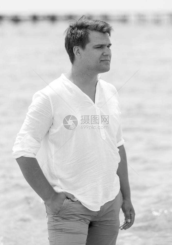 英俊青年男子在海滩上摆布的黑白肖像图片