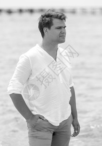 英俊青年男子在海滩上摆布的黑白肖像图片
