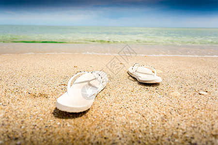 沙滩拖鞋在空沙滩上悬白翻滚的近镜头背景