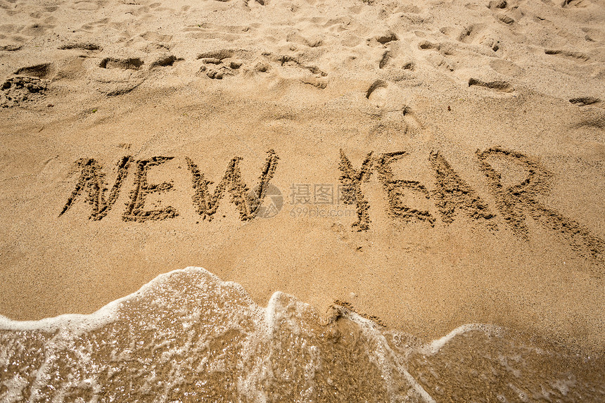 新年在沙滩上写作被海浪冲洗图片