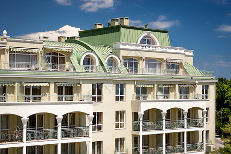 美丽的经典建筑配有电弧形阳台和绿色金属屋顶高清图片