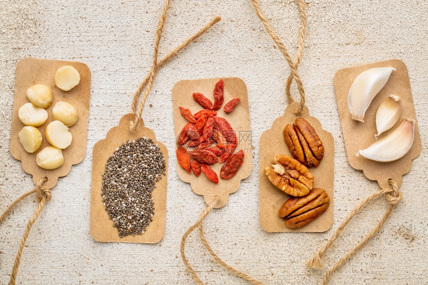与生锈的谷仓木麦地和核仁坚果汁子chia种和大蒜叶价格标签的超级食品抽象物健康饮食概念图片