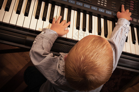 童年快乐和音小男孩玩黑数字硬盘钢琴合成器音乐图片