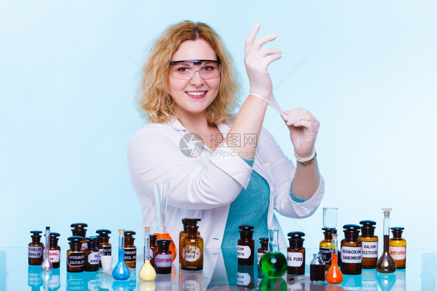 化学女家或生实验室助理或科学研究员在蓝色上装有化学玻璃软件试验瓶图片