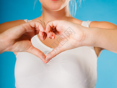 爱希望和慈善概念女双手在蓝背景上创造心脏标志符号工作室拍摄图片