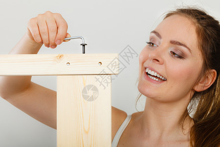女人用螺丝起子组装家具图片