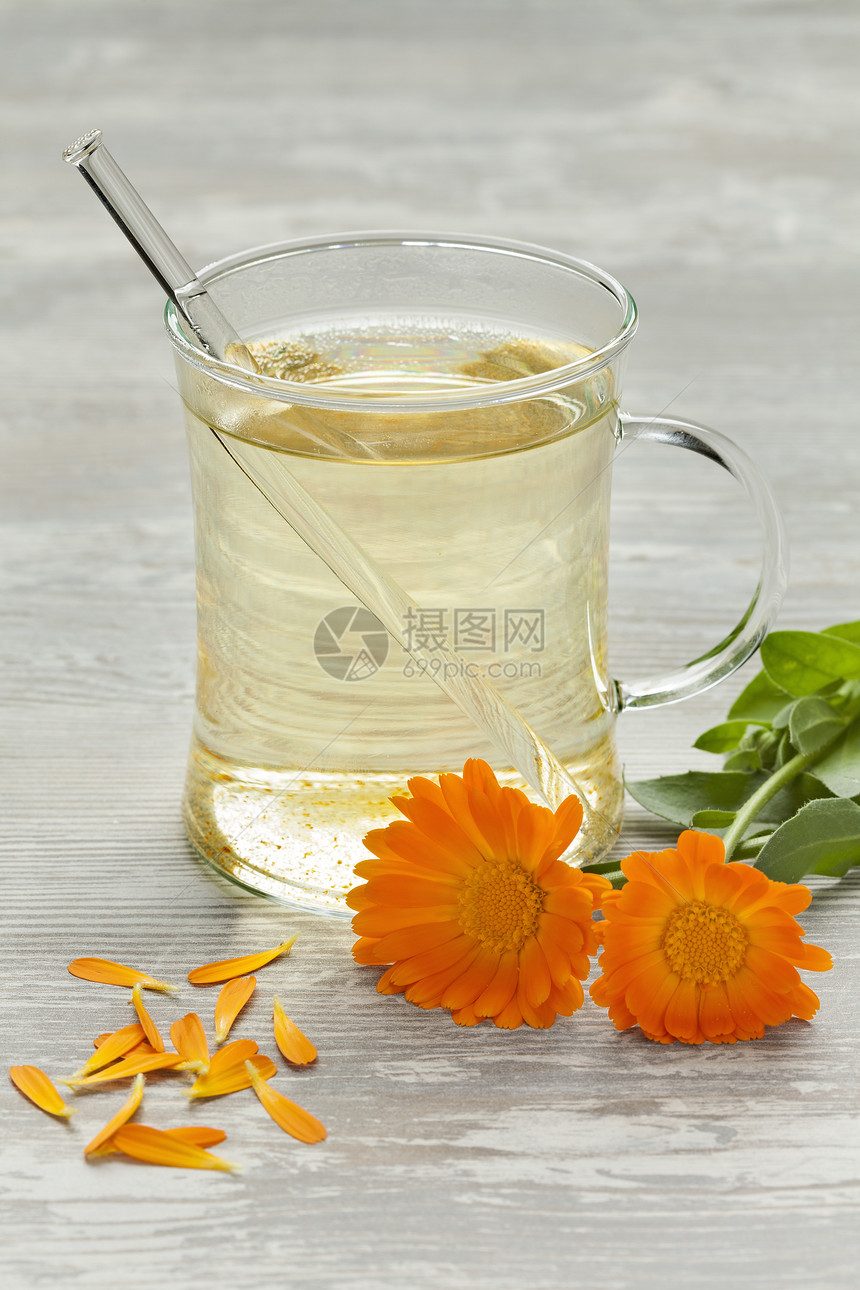 玻璃杯加茶壶马龙鲜花和叶子图片