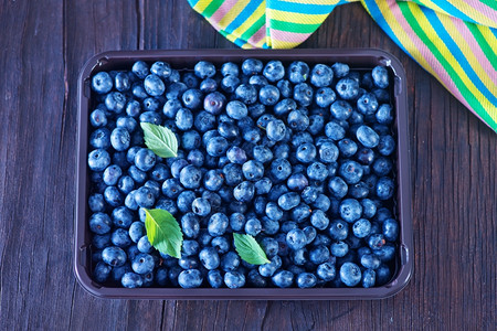 新鲜蓝莓放在桌子上蓝莓背景图片
