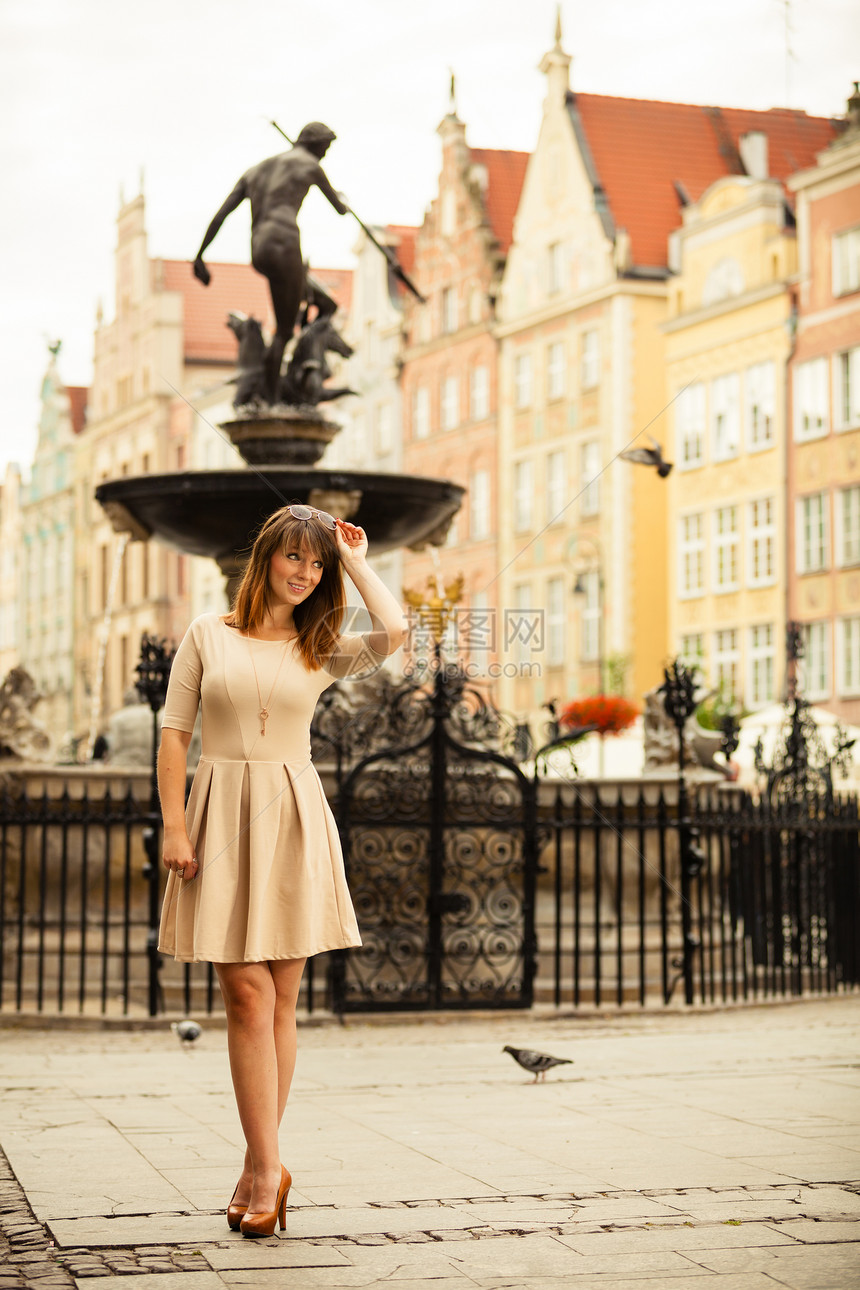 假期和旅游概念在旧城欧洲市GdanskDanzigNeptune喷泉波兰街外穿优雅服装的全身美女图片