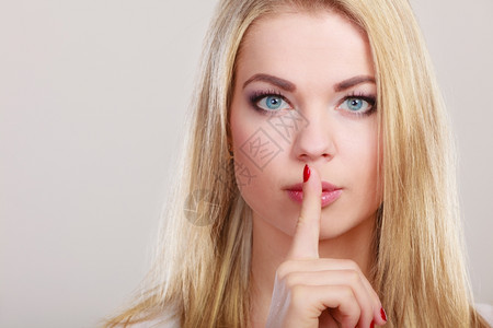 近身女人要求沉默或保密用手指在嘴唇上低语手势图片