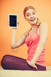 体育女孩手持平板电脑空屏幕显示复制间笑的女士愉快地宣传新的现代技术图片