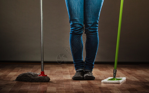 清洁家务概念女腿孩擦地板持有两把新的旧暗底拖图片