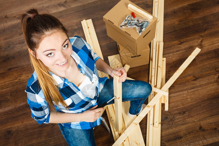 女人在家里组装家具图片