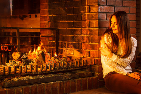 在壁炉旁休息的女人图片