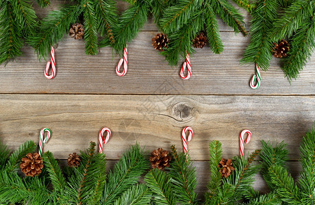 圣诞边框架的顶部和底有松树枝和甘蔗在生锈木板上布局以水平格式排列图片