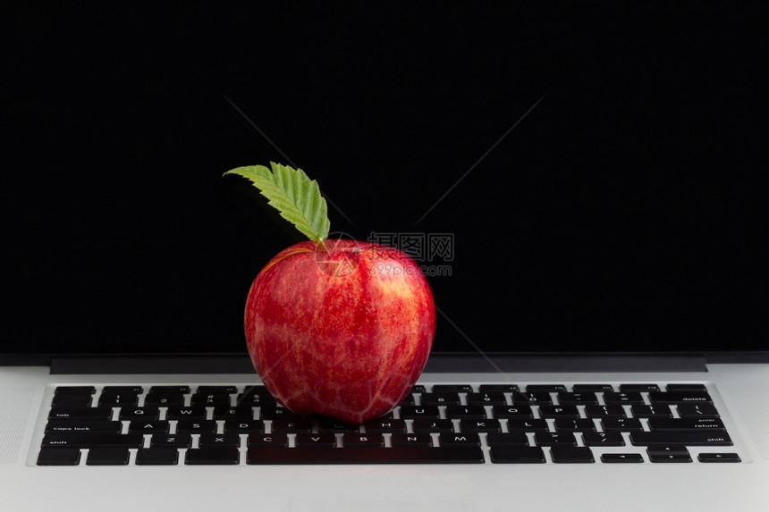 红色苹果在键盘上方背景中带有空白的监视屏幕图片