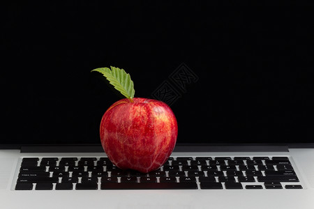 红色苹果在键盘上方背景中带有空白的监视屏幕背景图片