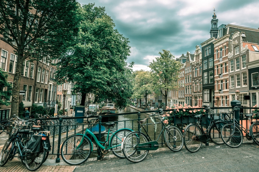 阿姆斯特丹运河和典型房屋船只和自行车的城市景象荷兰图片