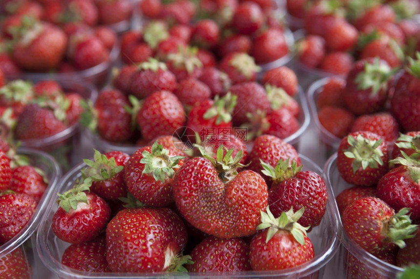 新鲜的多汁草莓在市场上图片
