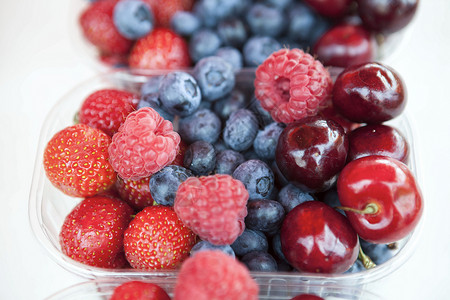 新鲜的草莓樱桃蓝在盒子上市场的图片