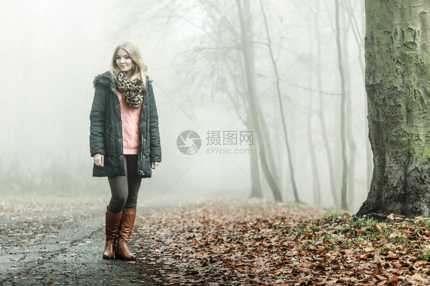女人在浓雾的白天浪漫秋森林公园露户外走来放松有色长相照片图片
