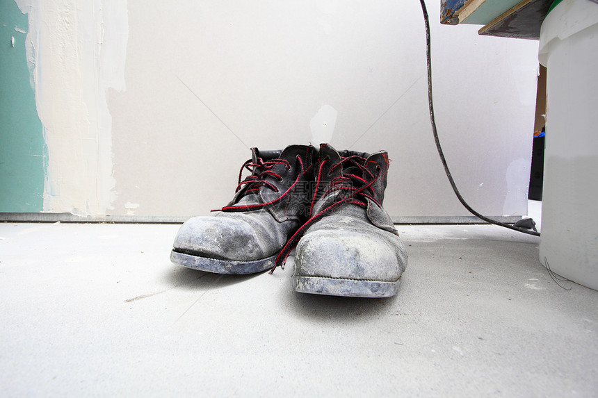 建筑工地一双旧的肮脏工作靴图片