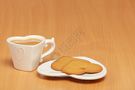 心形姜饼干热饮茶或桌上的咖啡图片