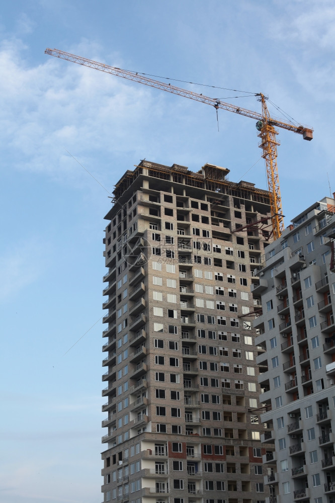 蓝色天空下的起重机和建筑房屋图片