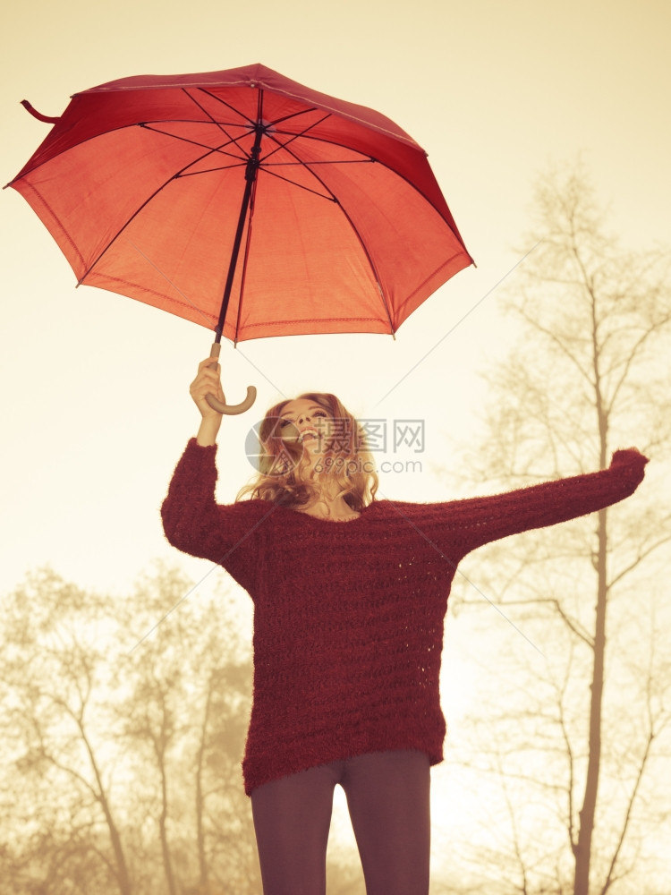 时装女郎在秋天公园放松雨伞时装女郎穿着马龙毛衣快乐的时装可爱女郎在浓雾的秋天公园放松雨伞图片