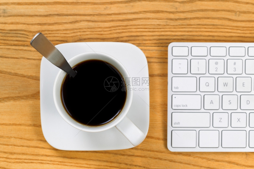 桌面的顶部视图有咖啡选择焦点在杯子顶部还有分键盘水平格式图片