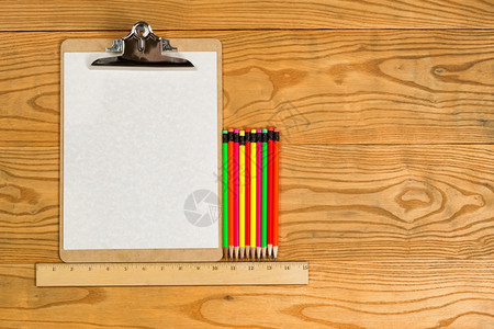 木制桌面上传统剪贴板空白纸标尺和彩色铅笔的顶端视图图片