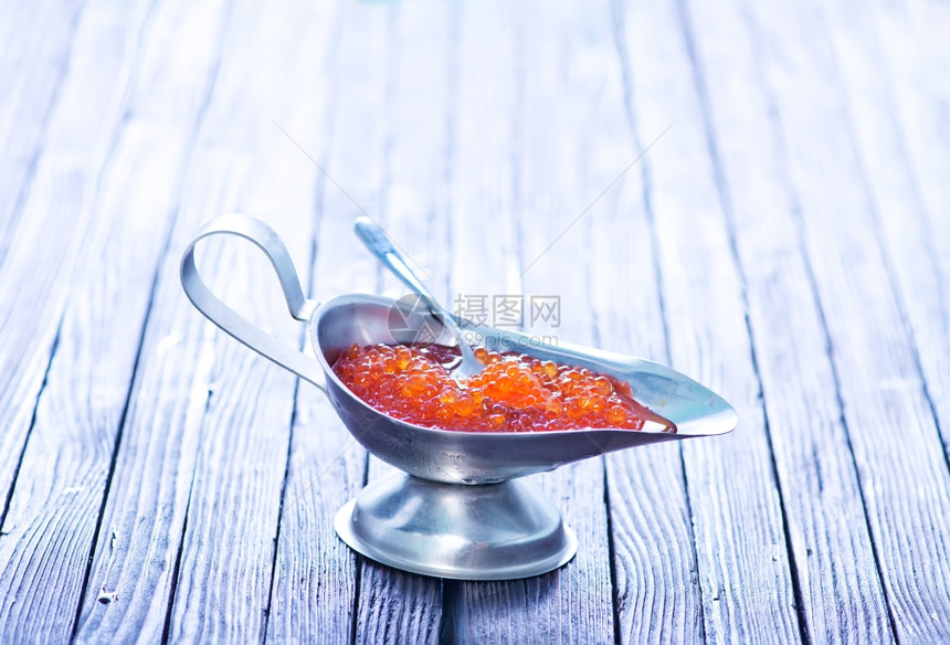 金属碗和桌子上的红鲑鱼酱图片