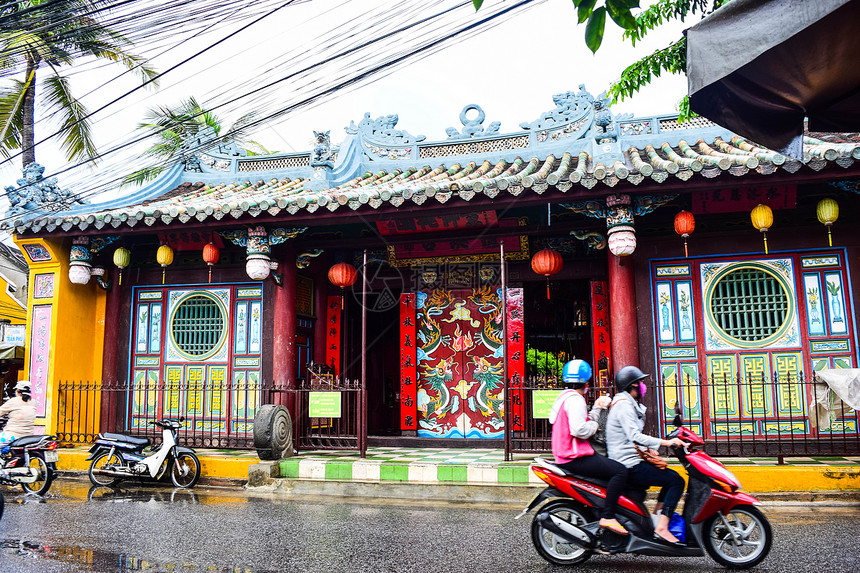 旅游者在雨天乘摩托车巡视霍伊古城图片