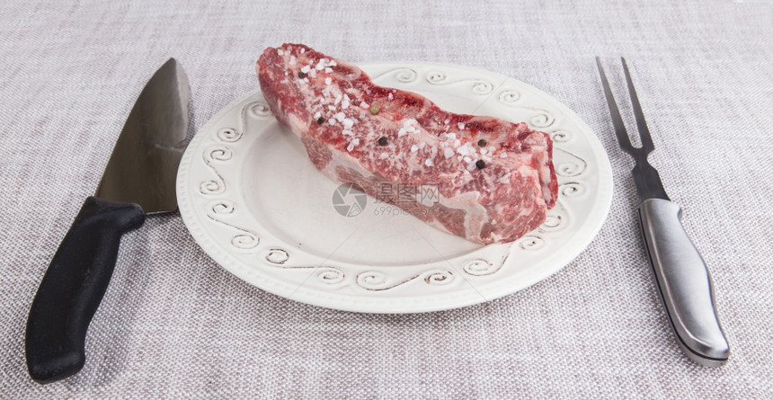 一块新鲜的大理石牛肉辣椒欧斯利肋骨躺在木质托盘上图片