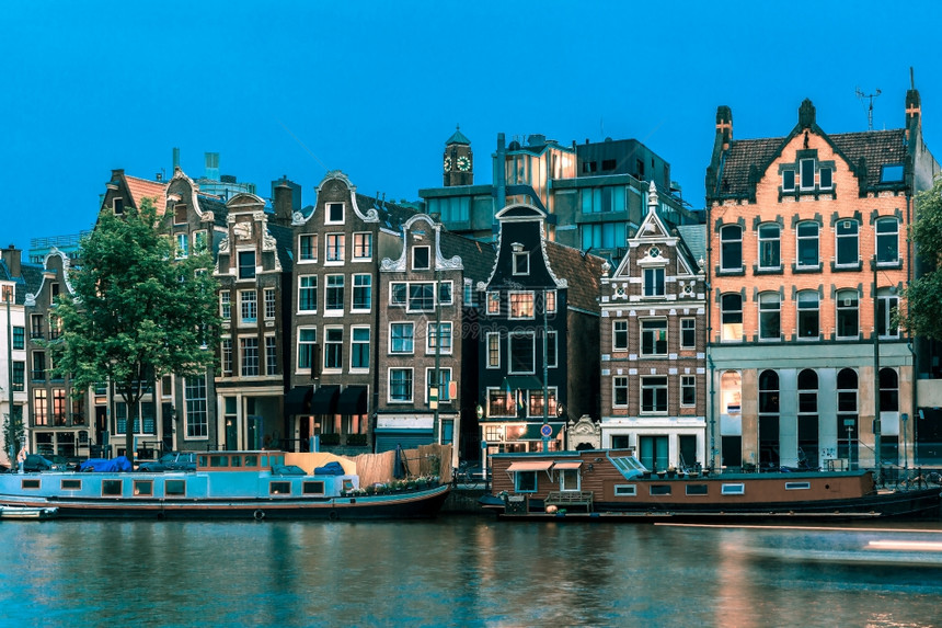 荷兰阿姆斯特丹运河典型的荷兰码头房屋和船只的夜间城市景色图片