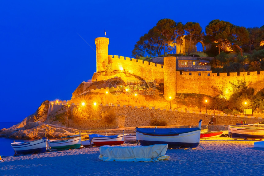 西班牙大普拉特加海滩堡垒和渔船夜景图片