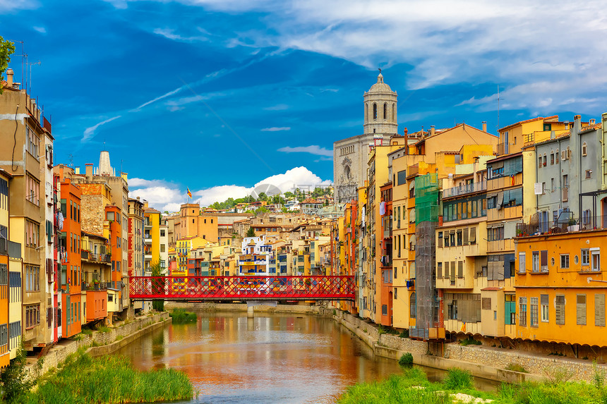 在西班牙加泰罗尼亚吉纳的Onyar河水中有多彩的黄色和橙房屋EiffelBridge旧鱼摊SantFeliu教堂和圣玛丽的背景图片