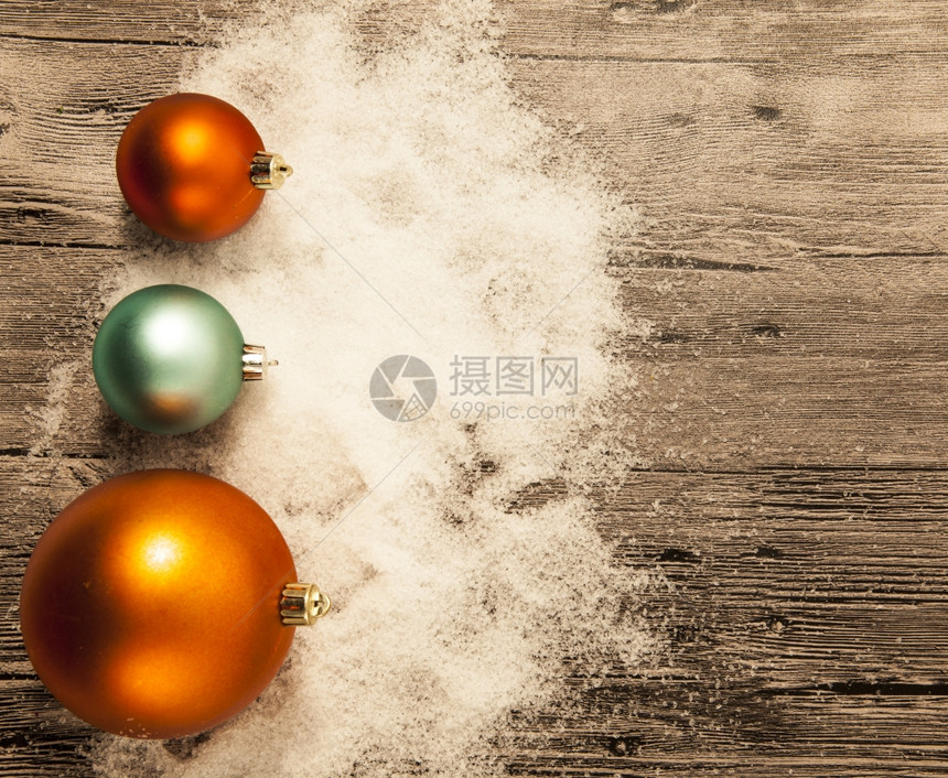 金色的圣诞球雪冬季和星在木制背景图片