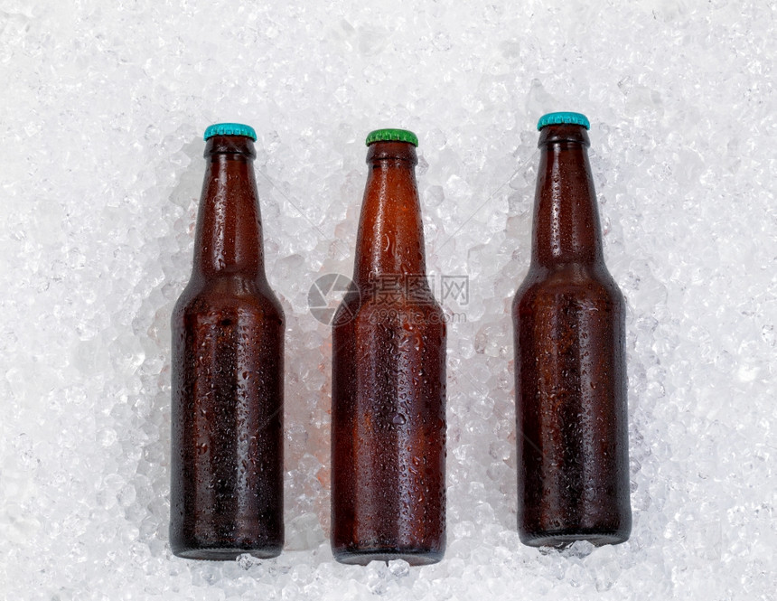 一瓶啤酒坐在边上冷却下来在堆积的冰图片