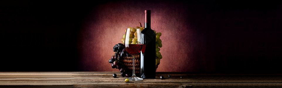 酒和葡萄放在篮子里黑背景图片